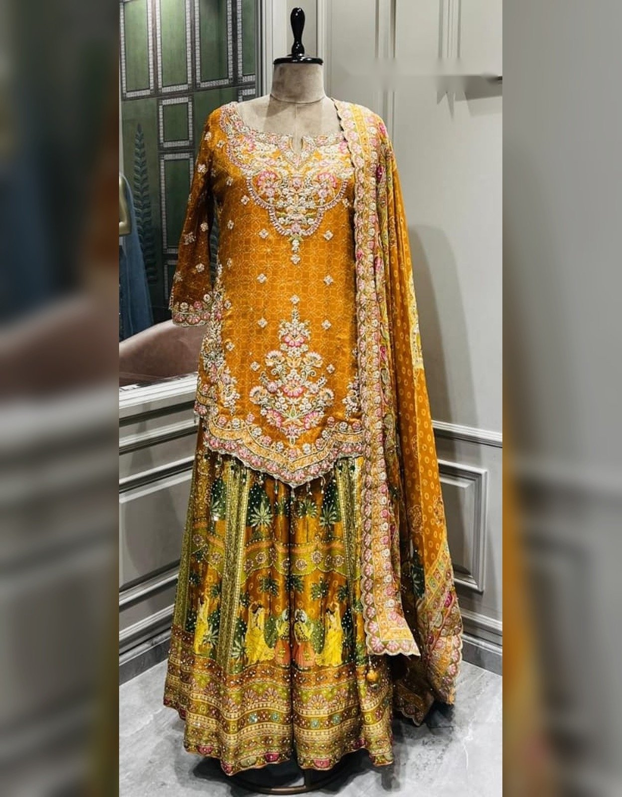 Mustard embroidered sharara suit with multicolour floral embroidery, wide-leg sharara and matching dupatta, displayed on a mannequin