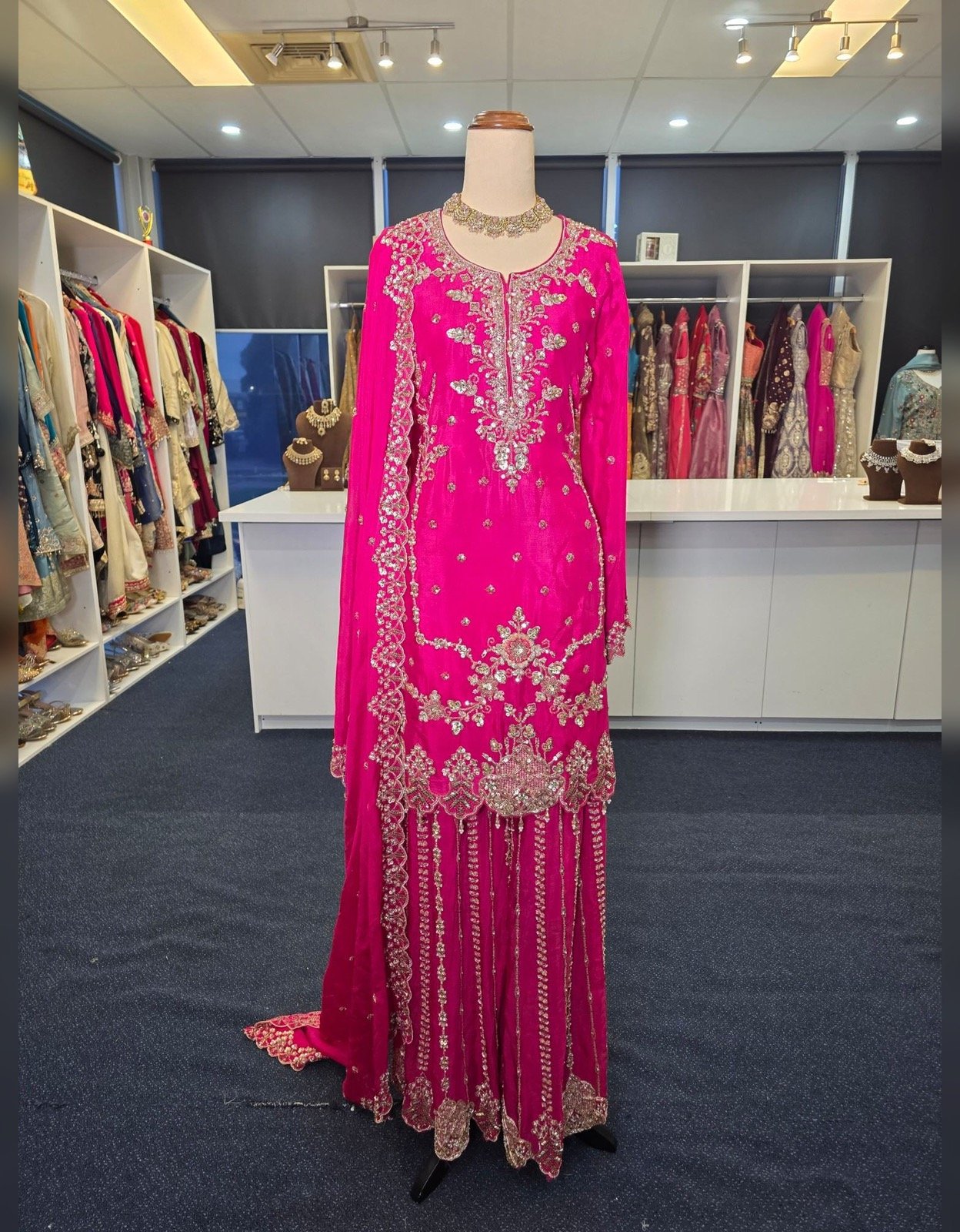 Bright pink embroidered sharara suit with intricate silver floral embroidery and matching dupatta, displayed at Raunak Boutique Epping